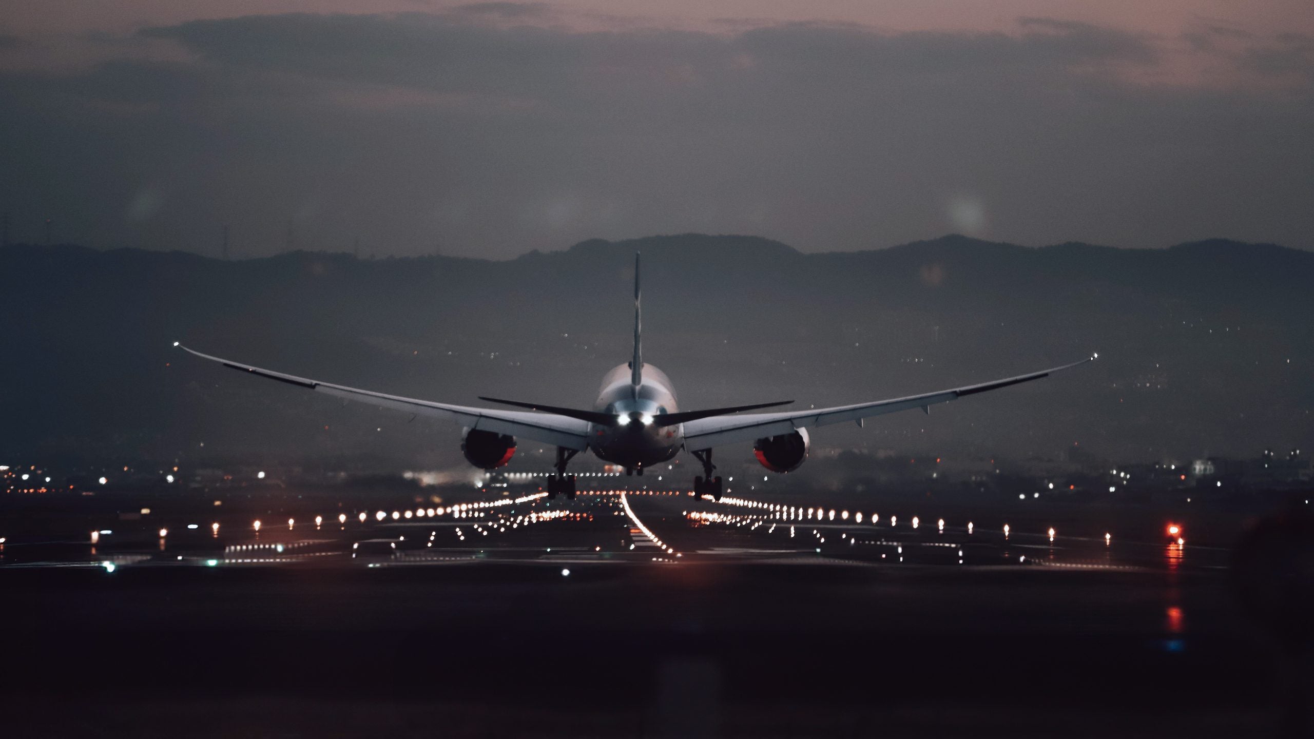 Aircraft landing on a lit runway at dusk