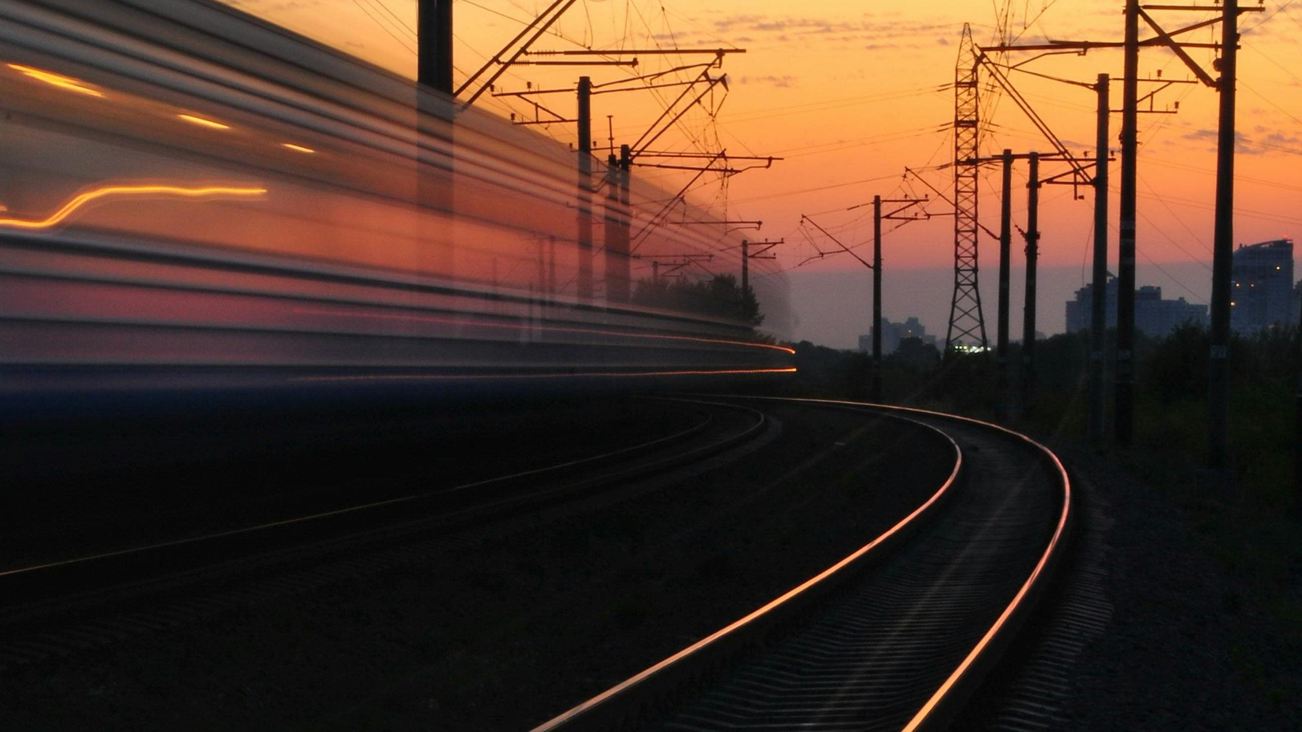 Railway line at dusk with train light trails